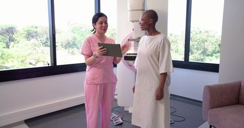 Nurse consulting African American woman before mammogram screening at radiology clinic