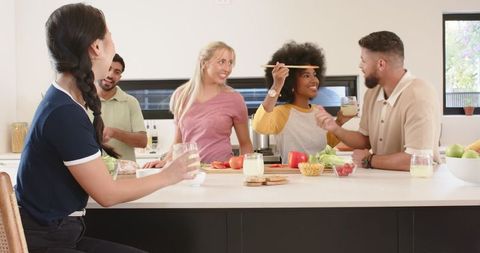 Friends Preparing Meal Together in Modern Kitchen with Smoothies