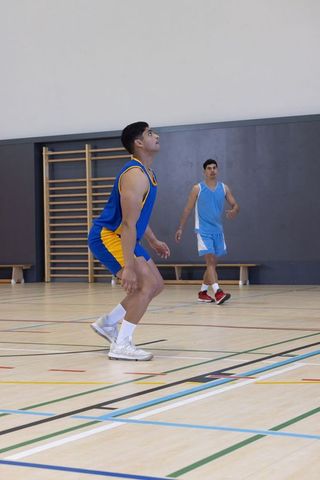 Basketball Players Ready for Rebound in Gymnasium