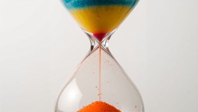 Colorful hourglass with vibrant sand trickling from top