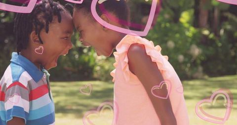 Playful sibling interaction with heart graphics in outdoor setting