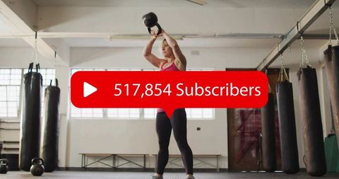 Woman pressing kettlebell overhead in boxing gym, social media subscriber overlay