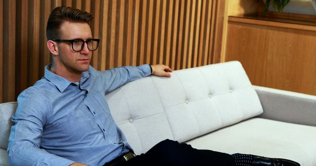 Businessman Relaxing on Modern Sofa in Office Space - Download Free Stock Images Pikwizard.com