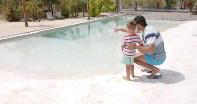 Father and son spending quality time by the poolside on a sunny vacation day. Good for use in family-oriented advertisements, travel brochures, and lifestyle blogs highlighting family bonding, summer activities, and vacation spots.