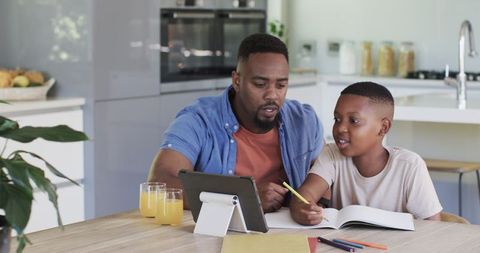 Father and Son Engaging in Learning Activity at Kitchen Table