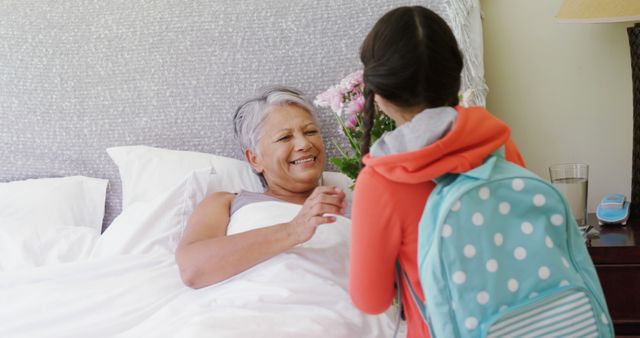 Grandmother in Bed Receiving Flowers from Granddaughter in Morning - Download Free Stock Images Pikwizard.com