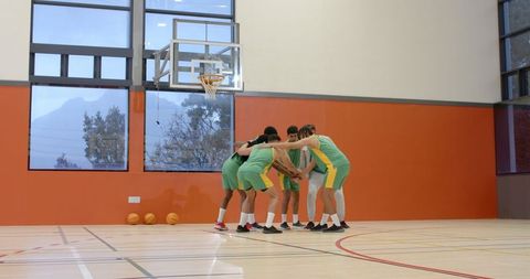 Diverse Basketball Team in Huddle for Motivation and Collaboration