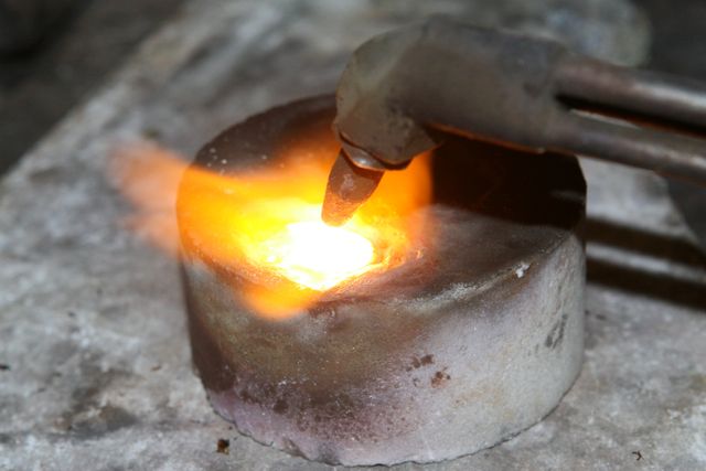 Scene showing furnace torch melting metal, suitable for industrial process visuals, metallurgy publications, educational material, foundry workshops.