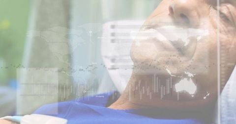 Male patient lying on hospital bed wearing wearable sensor with global analytics overlay