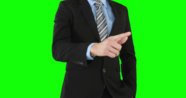 Businessman in a suit and tie, pointing forward with confidence, posing against green screen. Useful for presentations, business concepts, corporate training materials, marketing, leadership imagery, and gesture emphasis in visual communications.