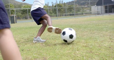 Child Kicking Soccer Ball on School Field Outdoor Activity