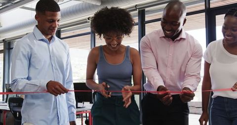 Diverse Team Celebrating Success with Ribbon-Cutting in Modern Office