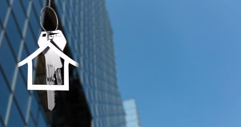 House Key with Urban Backdrop Reflecting Ownership Concept
