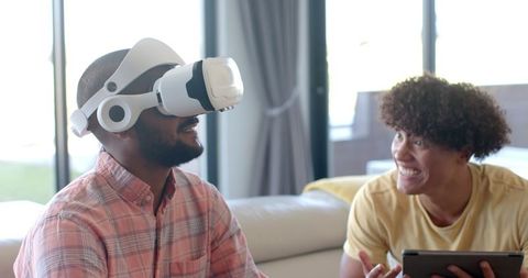 Marg towards: Man Immersed in Virtual Reality With Excited Friend