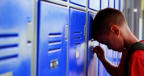 Stressed Schoolboy With Backpack Facing Blue Lockers