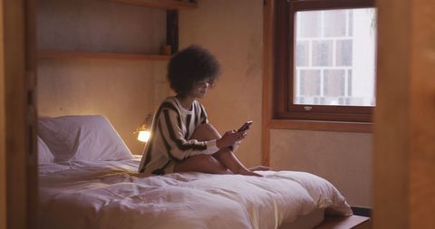 Relaxing in Cozy Bedroom While Engaging with Smartphone