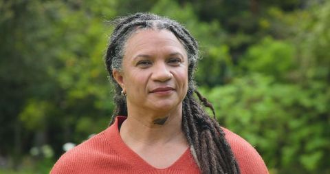 Mature woman with dreadlocks in garden setting