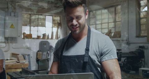 Craftspiring Artisan Using Laptop in Workshop Leveraging Technology