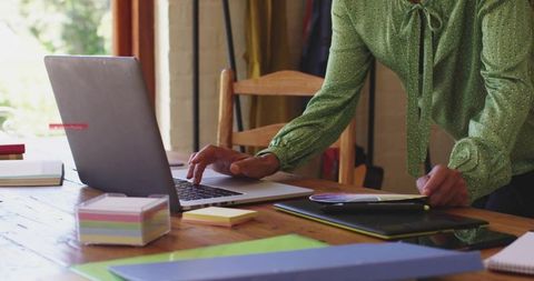 Woman in Green Blouse Managing Files on Home Office Desk