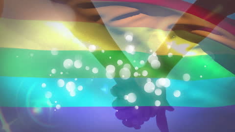 Hands Holding Under Rainbow Light Symbolizing Unity