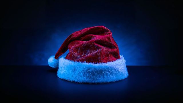 Sitting Red Velvet Santa Hat Glowing Blue Backlight Minimalist Holiday Still Life