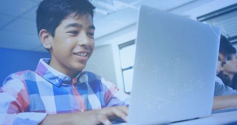 Smiling student learning math online using laptop in classroom