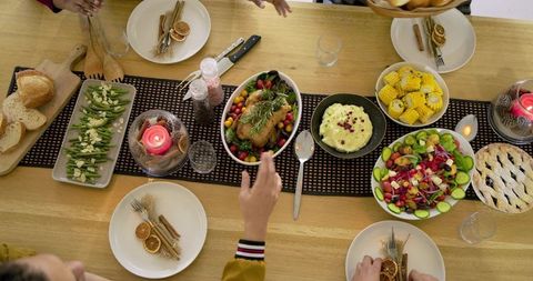 Diverse Family Gathering at Rustic Table Sharing Roast Chicken, Corn, Salad, Pie