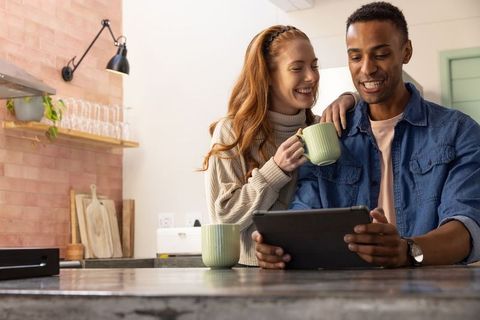 Happy Couple Enjoying Tech Together in Modern Kitchen Setting