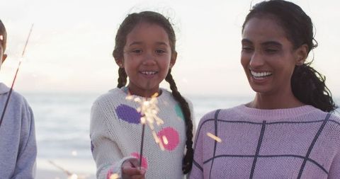 Family Celebrating with Sparklers on Beach