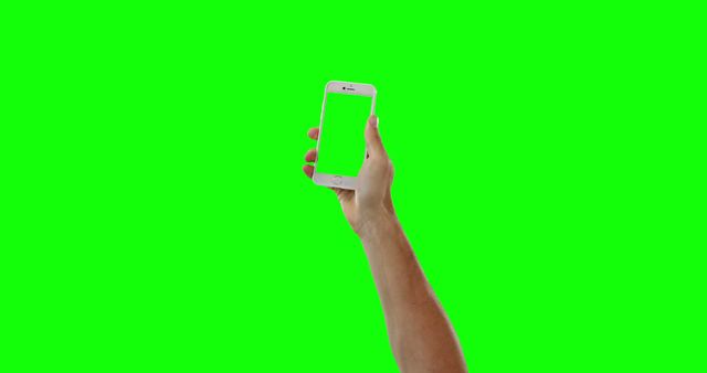 Hand holding smartphone with green screen background, useful for showcasing mobile apps, user interface, or technology-related presentations. Ideal for designers, developers, or for marketing purposes to highlight application features or functions.