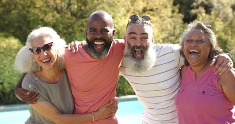 Senior Friends Embracing Laughter by Poolside on Serene Day