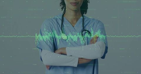 Clinician standing with crossed arms wearing scrubs and stethoscope with ecg data waveform