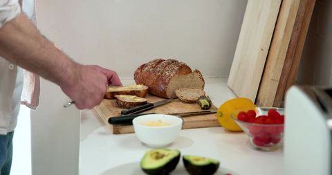 Slicing Artisanal Bread with Butter in Cozy Kitchen Enviroment