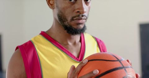 Determined Athlete Holding Basketball Indoors