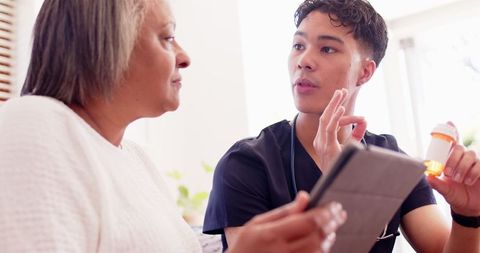 Young physiotherapist discussing medication with senior woman