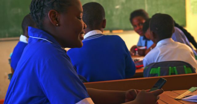 African american schoolgirl using smartphone in class room at elementary school - Download Free Stock Photos Pikwizard.com