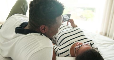 Expectant Parents Bonding Over Ultrasound at Home Together