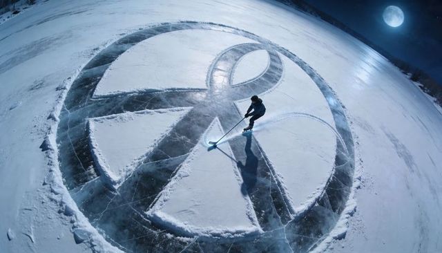 Skater carving giant geometric circle on frozen lake under moonlight and led glow