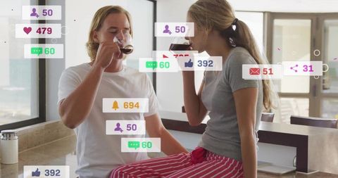 Young couple sipping coffee on kitchen counter with social media engagement icons overlay