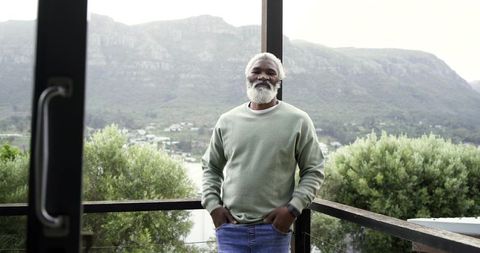Senior Man Enjoying Scenic Mountain View from Balcony