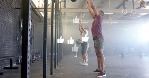 Group exercise medicine ball overhead raises in functional gym environment