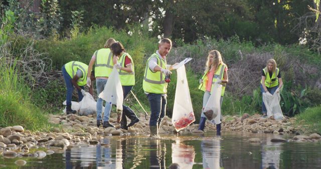 Diverse volunteers in hi vis vests clean a rural river, embodying ecological stewardship. - Download Free Stock Photos Pikwizard.com