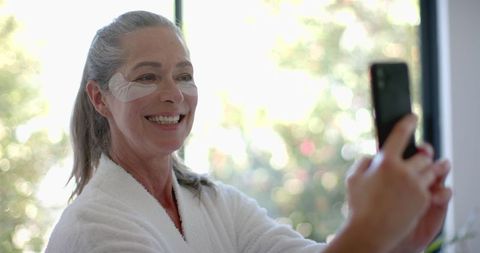 Smiling Mature Woman Taking Selfie in Relaxing Home Environment