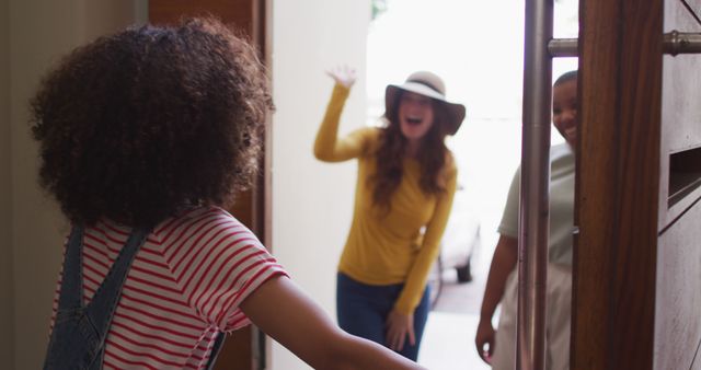 Young friends greeting each other at home doorway with excitement and smiles - Download Free Stock Images Pikwizard.com