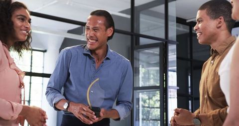 Diverse Colleagues Celebrating and Rewarding Team Success in Modern Office