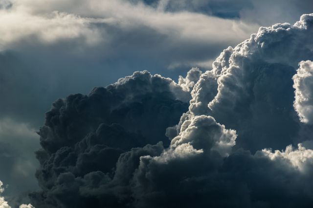 Captivating view of storm clouds forming in the sky with sunlight breaking through. Perfect for use in weather-related articles, backgrounds, nature blogs, or educational content about atmospheric phenomena and climate change.