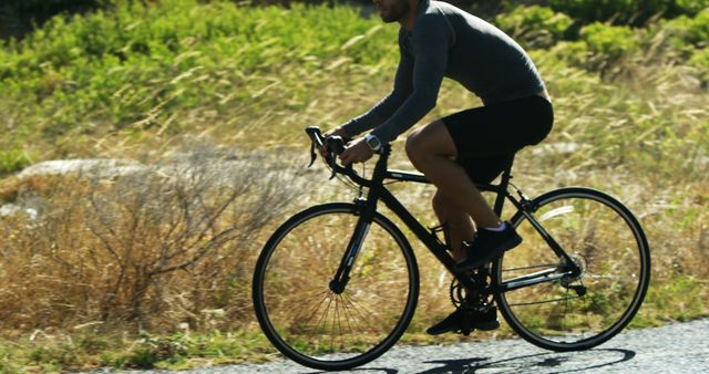 A middle-aged man is cycling along a road, with copy space - Download Free Stock Photos Pikwizard.com
