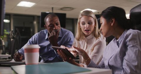Diverse Team Collaborating on Digital Project in Office