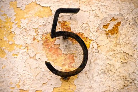 Rustic number 5 on peeling paint wall