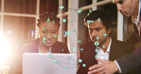 Collaborating professionals analyzing digital network and data on laptop in modern office